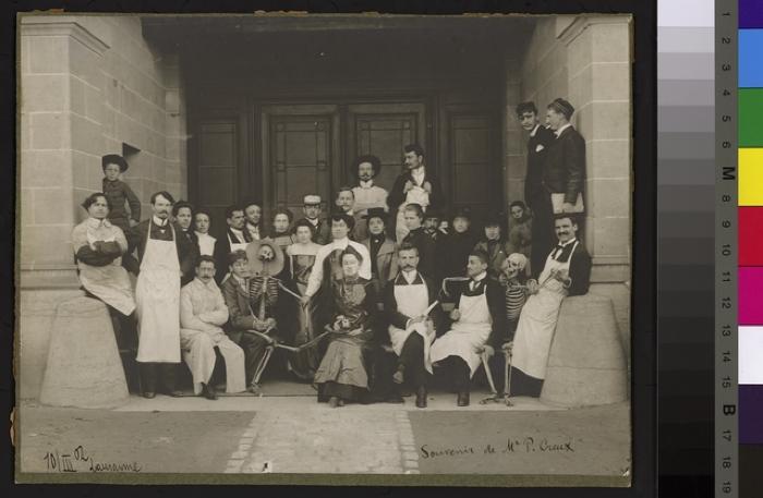 Volée d'anatomistes et de leurs professeurs sous le porche de l'Ecole de médecine. Le professeur Auguste Roud, nouvellement nommé, se tient assis, de face, sur la droite._x000D_
 On reconnaît les casquettes des sociétés d'étudiants. A droite et à gauche du g…